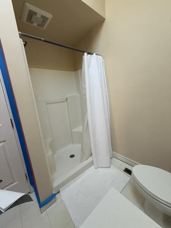 full bath featuring toilet, a stall shower, visible vents, and baseboards