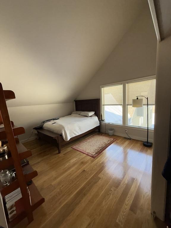 unfurnished bedroom featuring lofted ceiling and wood finished floors