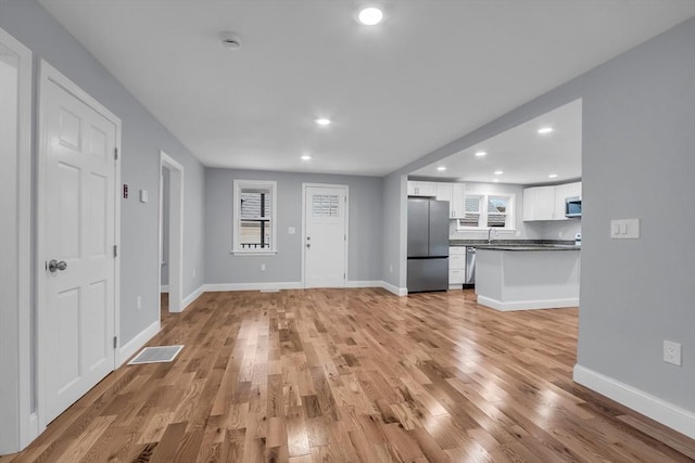 unfurnished living room featuring light hardwood / wood-style floors and sink