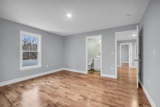 unfurnished bedroom with light wood-type flooring and ensuite bathroom