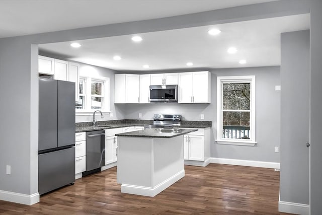 kitchen featuring dark hardwood / wood-style floors, a kitchen island, white cabinetry, and stainless steel appliances