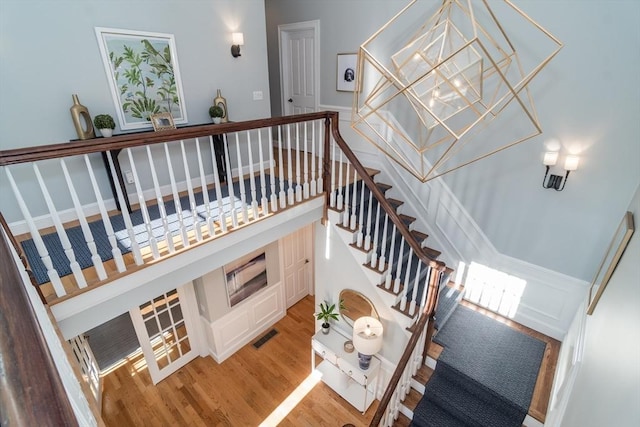 stairway featuring wood-type flooring and a high ceiling