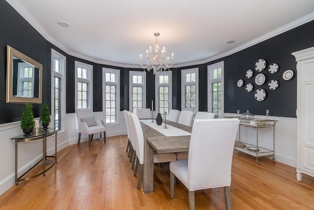 dining room with ornamental molding, a chandelier, and light wood-type flooring