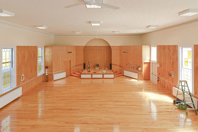 living room featuring ceiling fan, crown molding, light hardwood / wood-style flooring, and radiator