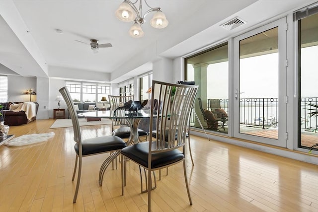 dining area featuring ceiling fan with notable chandelier and light hardwood / wood-style flooring