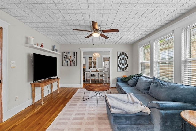 living room with ceiling fan, wood finished floors, and baseboards