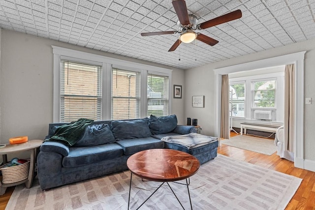 living area featuring ceiling fan, wood finished floors, and cooling unit