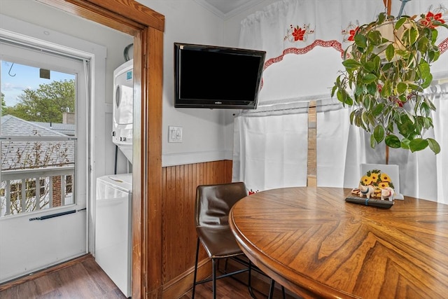 dining room with stacked washer / drying machine, wood finished floors, and ornamental molding