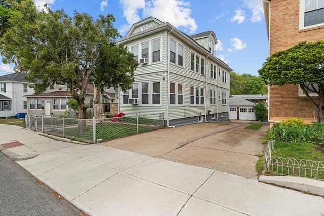 view of front of property featuring a garage, cooling unit, and an outdoor structure