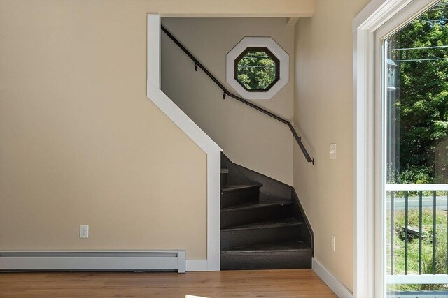 staircase featuring hardwood / wood-style floors and a baseboard radiator