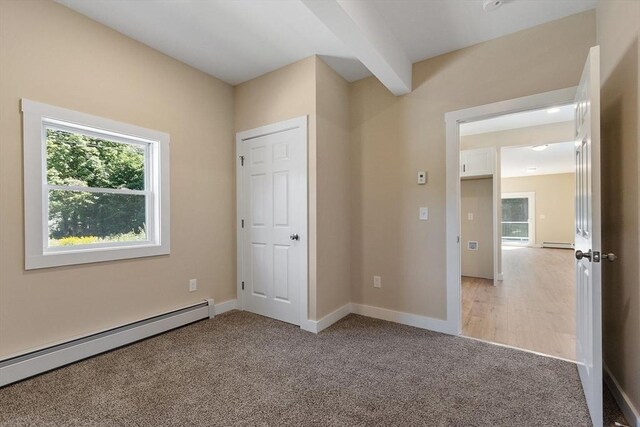 unfurnished bedroom with a baseboard radiator and light colored carpet