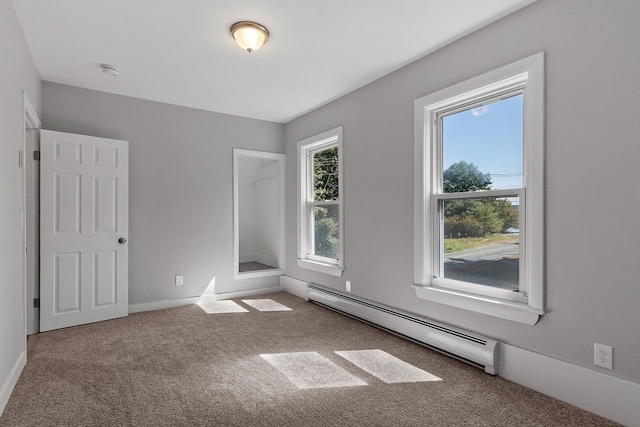 carpeted empty room with baseboard heating