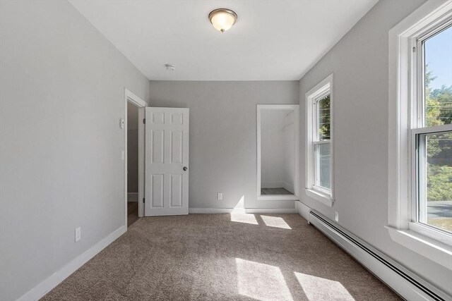 unfurnished bedroom with carpet flooring and baseboard heating