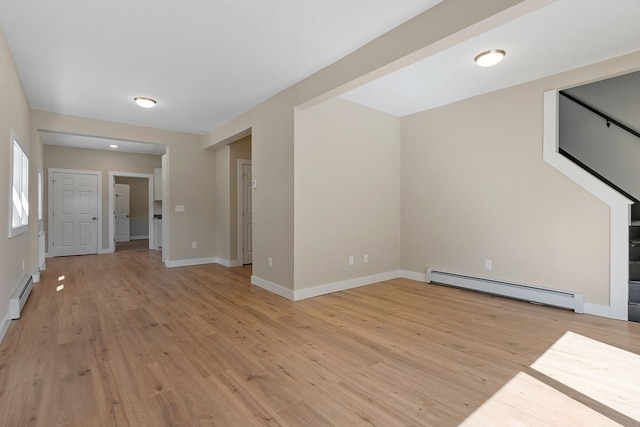 unfurnished living room featuring light wood-type flooring and a baseboard radiator