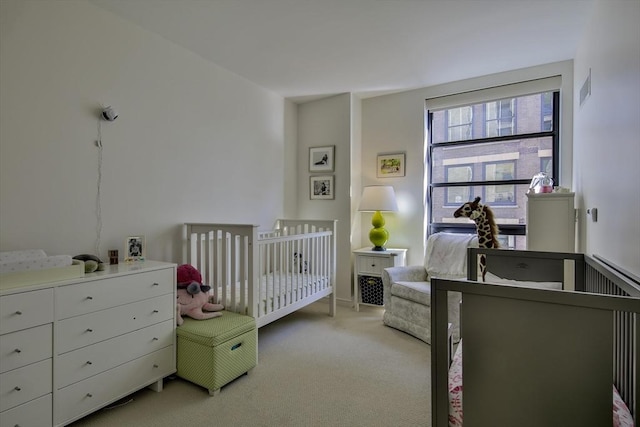 bedroom with light colored carpet and a crib