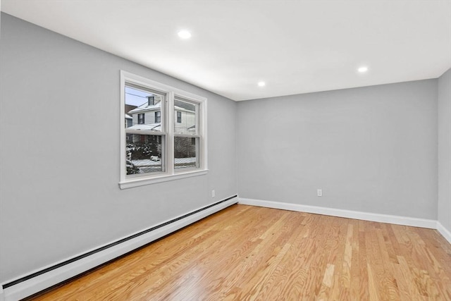 unfurnished room featuring light hardwood / wood-style flooring and a baseboard heating unit