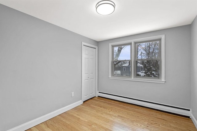 spare room with light hardwood / wood-style floors and a baseboard radiator