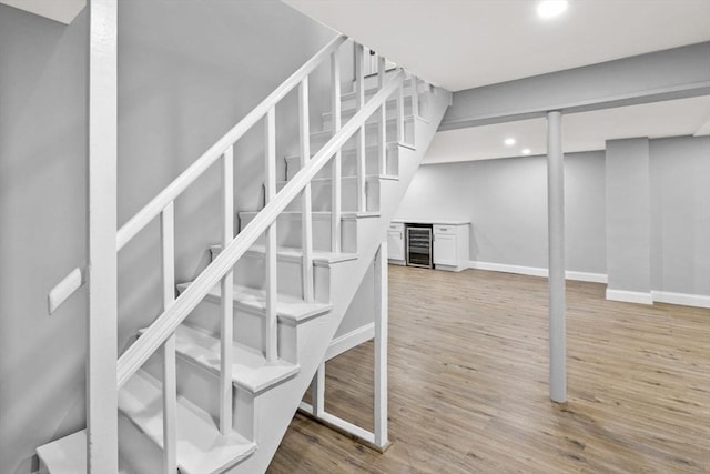 staircase with wood-type flooring and beverage cooler