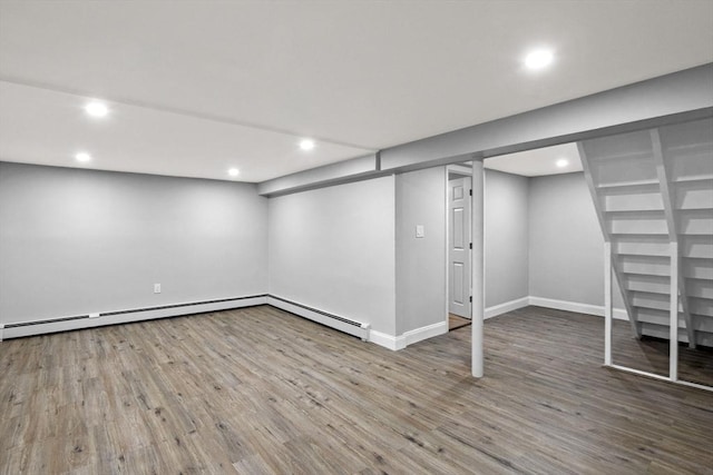 basement featuring a baseboard radiator and wood-type flooring