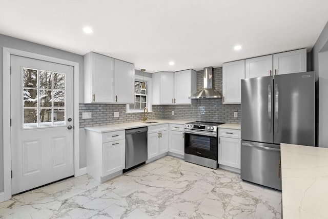 kitchen featuring white cabinets, wall chimney exhaust hood, stainless steel appliances, sink, and backsplash