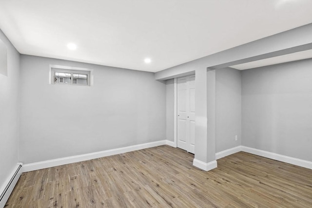 basement with a baseboard radiator and light wood-type flooring