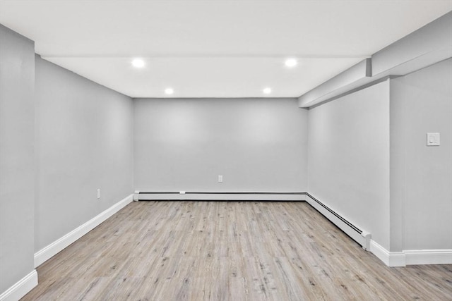 empty room featuring light hardwood / wood-style floors and a baseboard heating unit