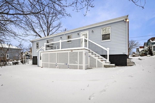 snow covered house featuring a deck