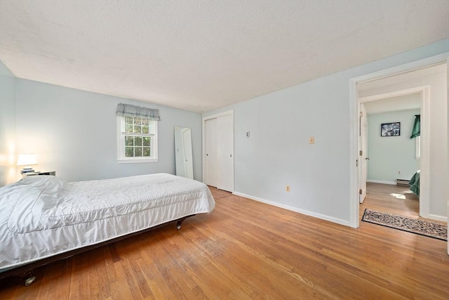 1102 State Rd, Plymouth, MA 02360 - bedroom featuring hardwood / wood-style flooring, a textured ceiling, baseboard heating, and a closet