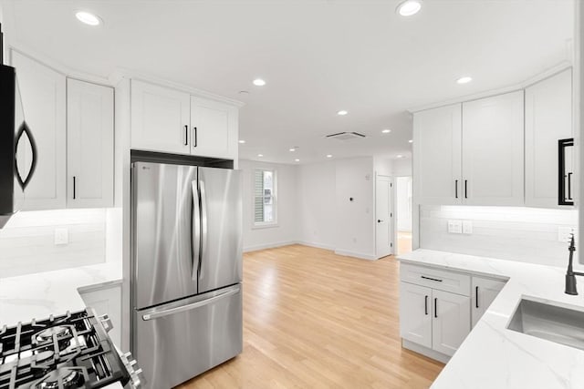 63 Oak St Unit 2, Somerville, MA 02143 - kitchen with freestanding refrigerator, recessed lighting, tasteful backsplash, white cabinetry, and light wood-style flooring