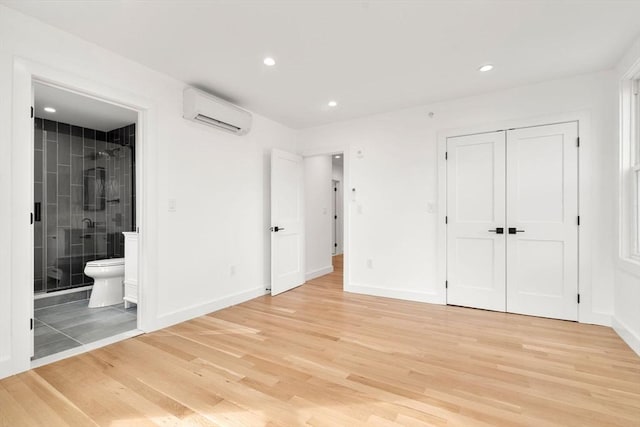 63 Oak St Unit 2, Somerville, MA 02143 - unfurnished bedroom featuring an AC wall unit, light wood-style flooring, baseboards, and recessed lighting