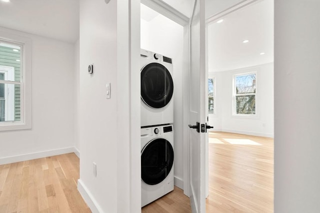 63 Oak St Unit 2, Somerville, MA 02143 - laundry room featuring stacked washer / dryer, light wood-style floors, baseboards, and recessed lighting