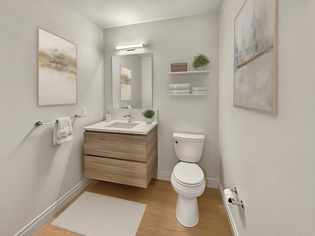 bathroom with vanity, wood-type flooring, and toilet