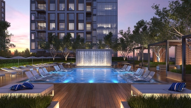 pool at dusk featuring a wooden deck