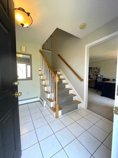 28 Myrtle St, Millis, MA 02054 - foyer entrance with stairway, a baseboard heating unit, light tile patterned flooring, and light colored carpet