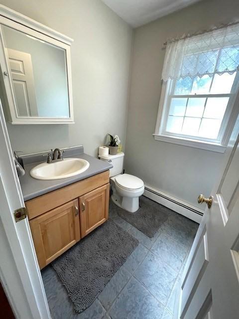 28 Myrtle St, Millis, MA 02054 - half bathroom with a baseboard radiator, vanity, toilet, and tile patterned floors