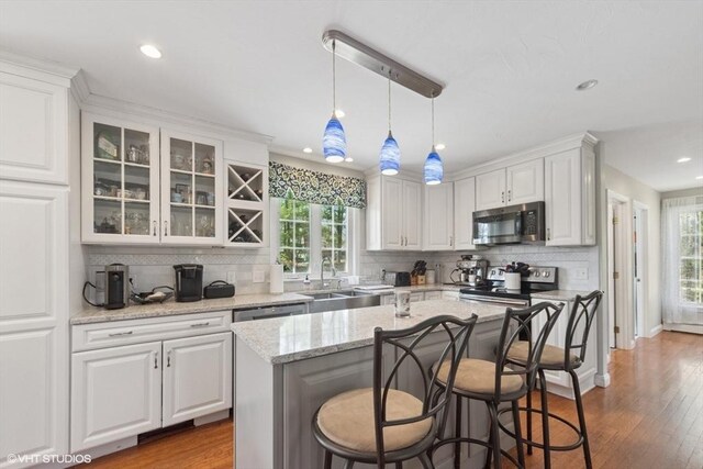 28 Myrtle St, Millis, MA 02054 - kitchen featuring stainless steel appliances, a sink, decorative backsplash, healthy amount of natural light, and recessed lighting
