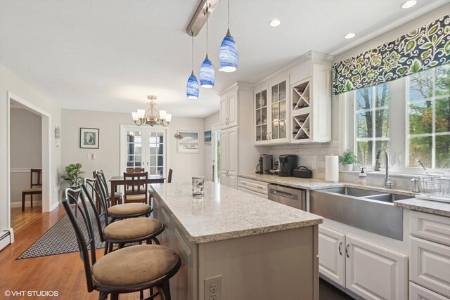 28 Myrtle St, Millis, MA 02054 - kitchen with a sink, white cabinets, a chandelier, glass insert cabinets, and a kitchen island