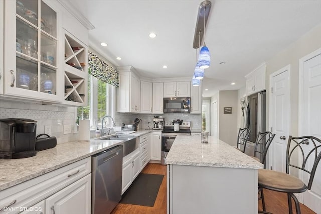 28 Myrtle St, Millis, MA 02054 - kitchen with appliances with stainless steel finishes, a sink, white cabinetry, dark wood-type flooring, and a center island