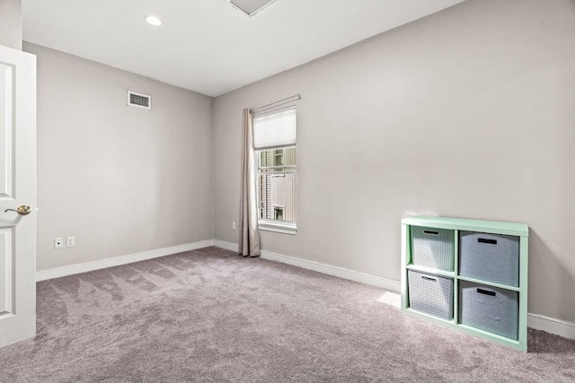 carpeted spare room featuring baseboards and visible vents