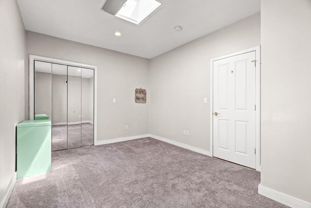 unfurnished bedroom featuring baseboards, carpet, and a closet