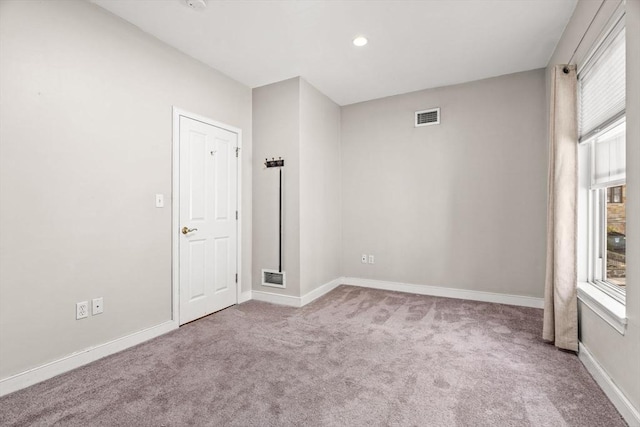 empty room featuring baseboards, visible vents, and carpet