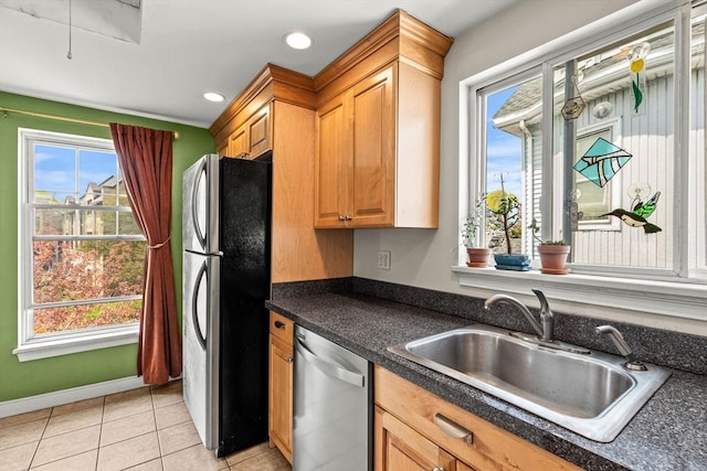 kitchen with dark countertops, recessed lighting, a sink, appliances with stainless steel finishes, and light tile patterned floors