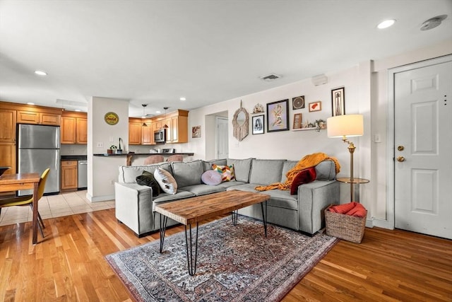 living area featuring baseboards, recessed lighting, light wood-style flooring, and visible vents