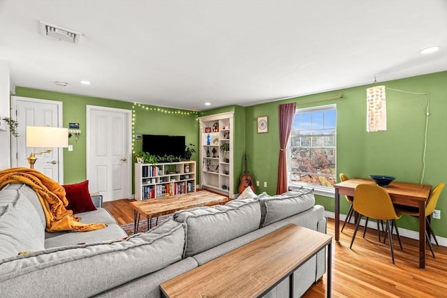 living area with baseboards, recessed lighting, wood finished floors, and visible vents