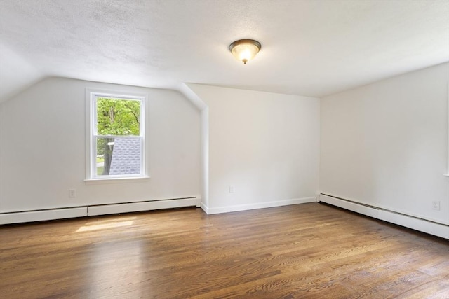 133 Jean Dr, Seekonk, MA 02771 - bonus room with a baseboard heating unit, wood finished floors, vaulted ceiling, baseboard heating, and a textured ceiling
