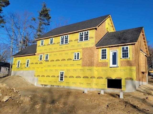 view of side of property with roof with shingles