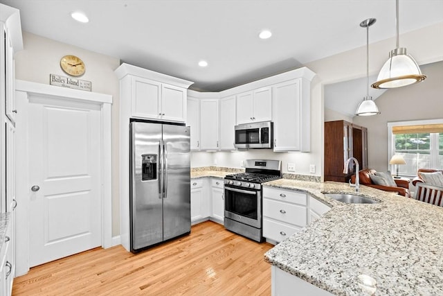 33 Inkberry Ln, Plymouth, MA 02360 - kitchen with appliances with stainless steel finishes, a sink, a peninsula, light wood finished floors, and white cabinets