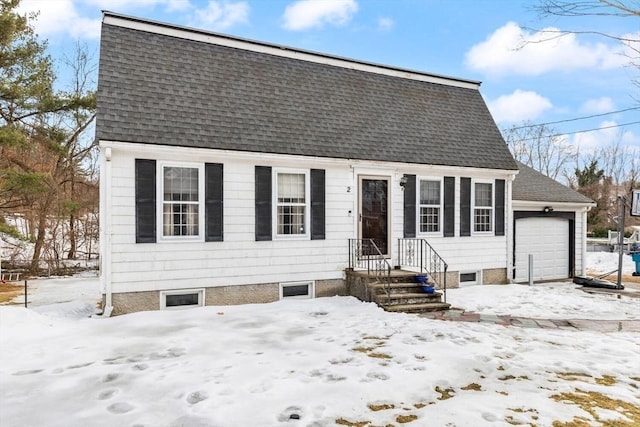 colonial inspired home with an attached garage and a shingled roof