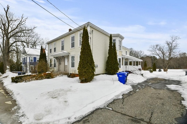 view of snowy exterior with a chimney