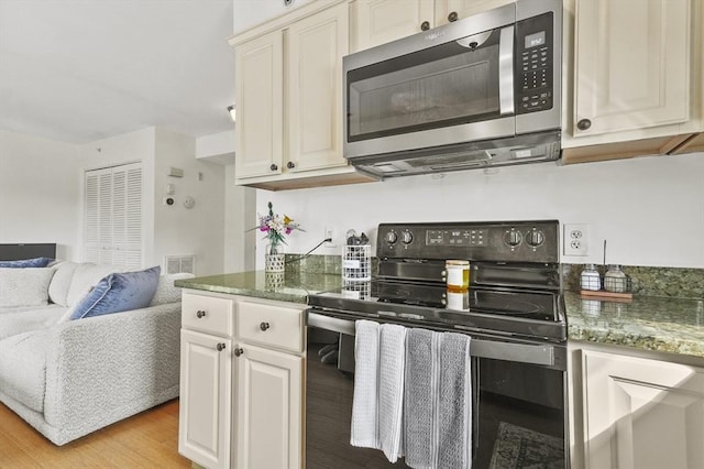 226-236 River St Unit 5, Haverhill, MA 01832 - kitchen featuring appliances with stainless steel finishes, open floor plan, light wood-type flooring, and white cabinetry